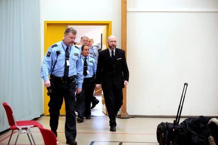 Anders Behring Breivik (R) is escorted by police officers to the courtroom on the fourth day of the appeal case in Borgarting Court of Appeal at Telemark prison in Skien, Norway, January 13, 2017. NTB Scanpix/Lise Aaserud/via REUTERS