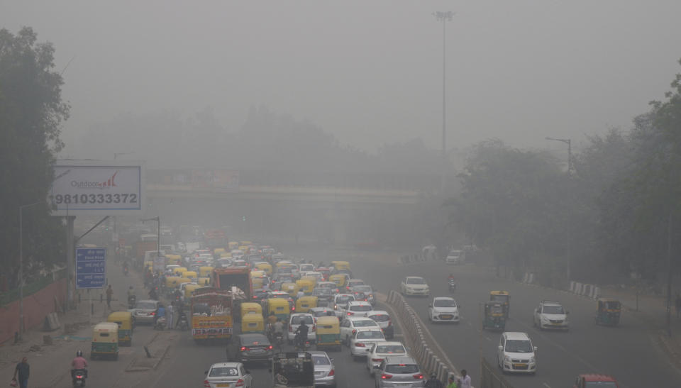 In this Sunday, Nov. 3, 2019, file photo, vehicles wait for a signal at a crossing as the city enveloped in smog in New Delhi, India. Authorities in New Delhi are restricting the use of private vehicles on the roads under an "odd-even" scheme based on license plates to control vehicular pollution as the national capital continues to gasp under toxic smog. (AP Photo/Manish Swarup, File)