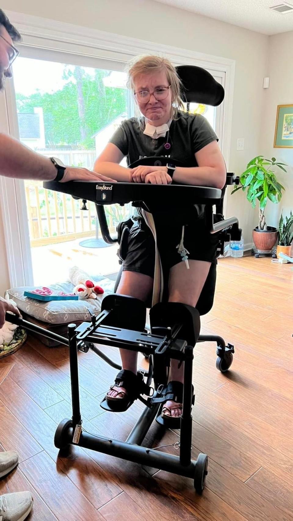 Caitlin practices at home with a loner standing frame, which is ‘tremendously helpful to her recovery’ and which her mother is attempting to get insurance to help finance (Facebook/Darlene Jensen)