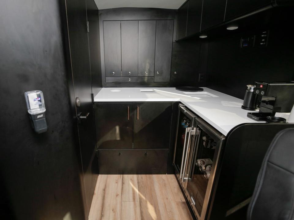 The galley at the rear of the bus. A hand sanitizer bottle is mounted on the right.