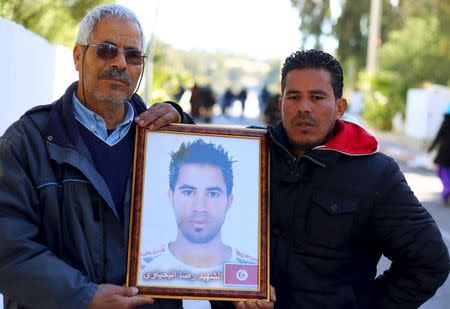 Othman Yahyaoui (L) holds a photograph of his son Ridha Yahyaoui, who committed suicide, in Kasserine, Tunisia January 21, 2016. REUTERS/Amine Ben Aziza