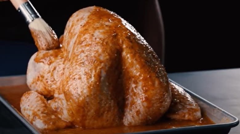 Brushing marinade on turkey