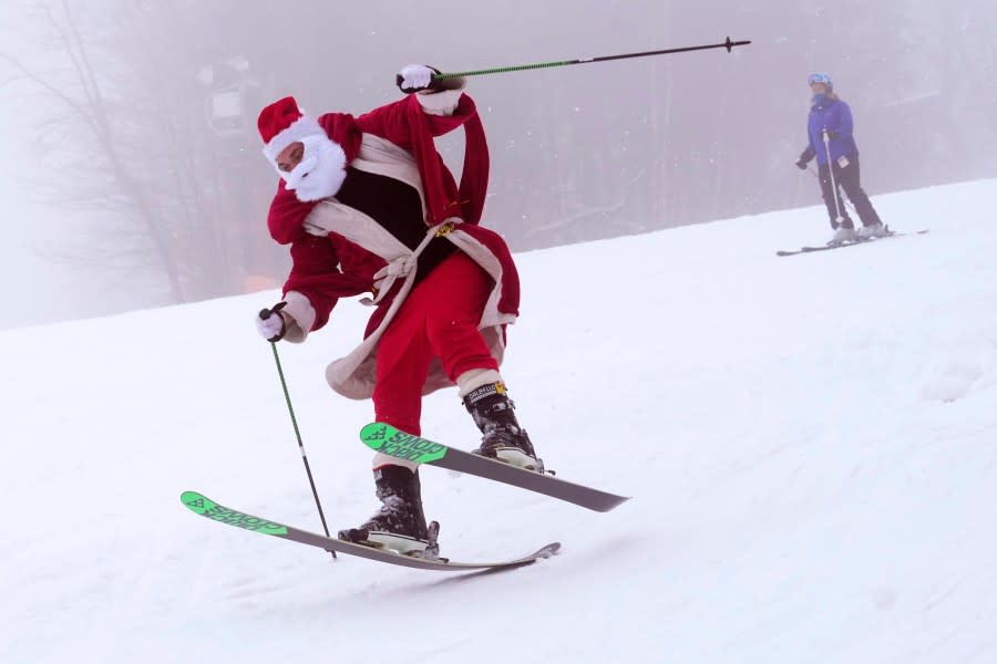 A skier dressed as Santa Claus works to regain his balance, Sunday, Dec. 10, 2023, at the Sunday River ski resort in Newry, Maine. The annual Santa Sunday event raises money for local charities. (AP Photo/Robert F. Bukaty)