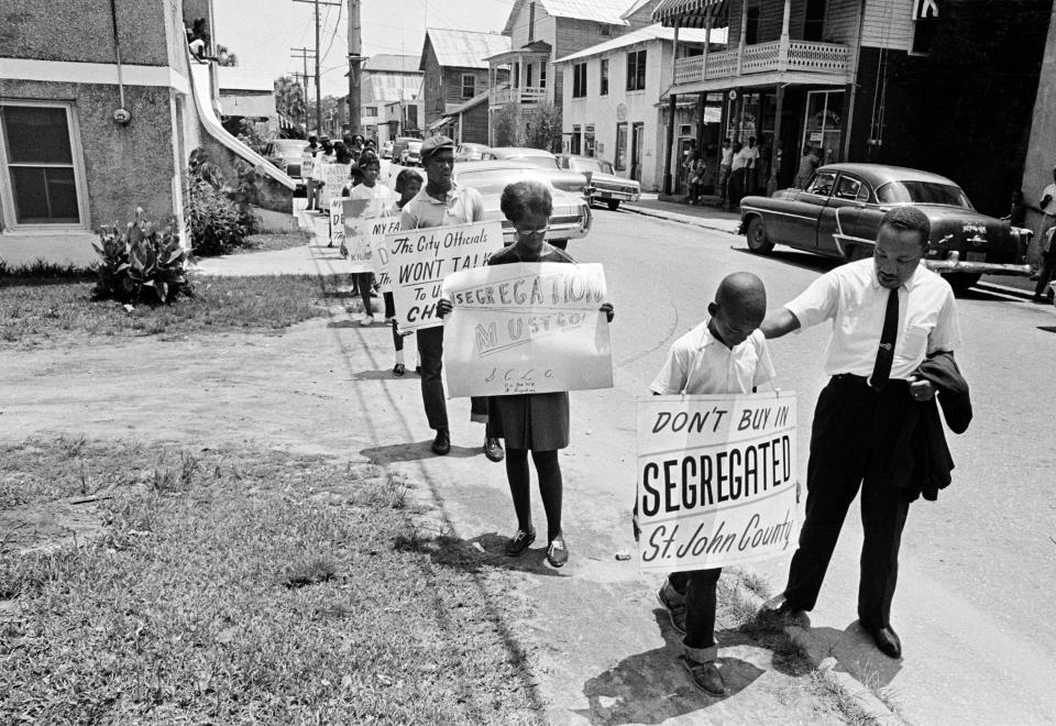 Rosemary McGill holds a sign as Dr. Martin Luther King Jr. talks to an unidentified boy during one of several marches in St. Augustine.
