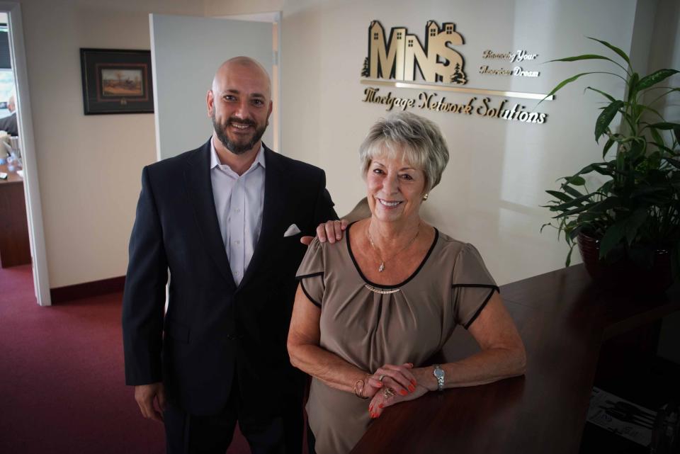 Michael Rappucci, vice president, stands with his mother Cheryl Rappucci, who is the president of Mortgage Network Solutions, in the lobby of their Brandywine Hundred business.