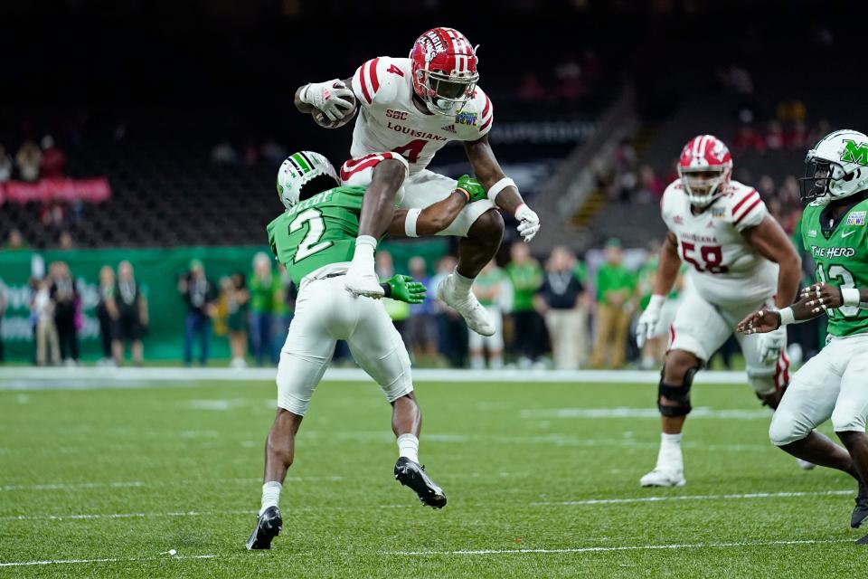 Running back Montrell Johnson Jr. (4), shown here trying to leap over Marshall safety Cory McCoy (2) in UL's New Orleans Bowl win over the Thundering Herd, is leaving the Ragin' Cajuns for Florida.