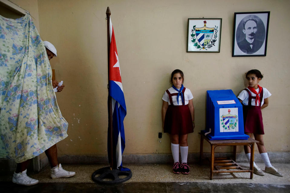 <p>In der kubanischen Hauptstadt Havanna gibt ein Wähler in einem Wahllokal seine Stimme ab. Neben der Wahlurne stehen zwei Mädchen der Pioniere, einem kubanischen Jugendverband. Der Tradition nach salutieren die Kinder jedes Mal, wenn ein Wähler seinen Stimmzettel abgibt. (Bild: Reuters/Alexandre Meneghini) </p>