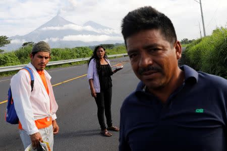 Eufemia Garcia, 48, who lost 50 members of her family during the eruption of the Fuego volcano, holds food as she walks to her town in search of her family on the outskirts of San Miguel Los Lotes in Escuintla, Guatemala, June 12, 2018. REUTERS/Carlos Jasso