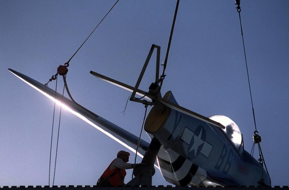 A replica of Gen. Chuck Yeager’s P-51 Mustang WWII-era fighter plane is lifted on Dec. 7, 1999, by a crane atop a 46-foot reproduction of an airport control tower built above the new Aces Supper Club near Interstate 80.