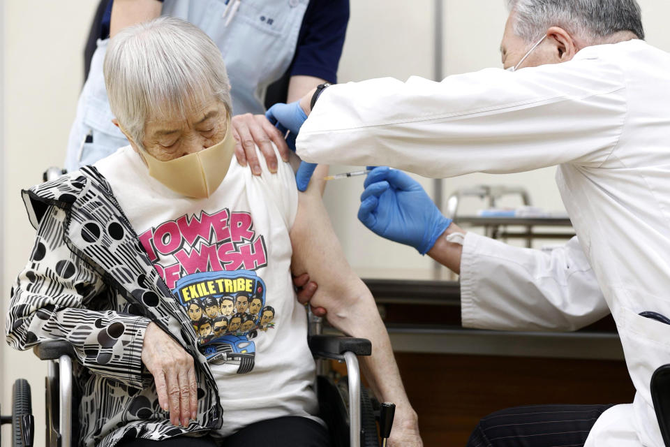 An elderly woman receives her first dose of Pfizer's COVID-19 vaccine at a special nursing home in Itami, Hyogo prefecture, western Japan, Monday, April 12, 2021. Japan started its vaccination drive with medical workers and expanded Monday to older residents, with the first shots being given in about 120 selected places around the country. (Kyodo News via AP)