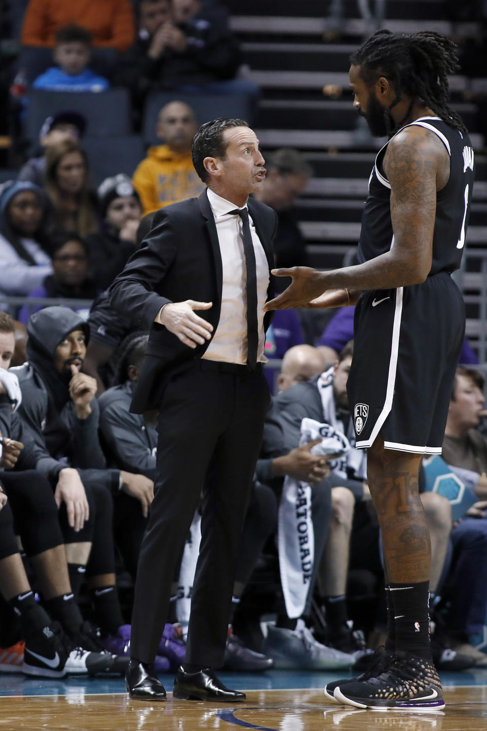 Brooklyn Nets coach Kenny Atkinson, left, talks with DeAndre Jordan during the first half of the team's NBA basketball game against the Charlotte Hornets in Charlotte, N.C., Friday, Dec. 6, 2019. (AP Photo/Bob Leverone)