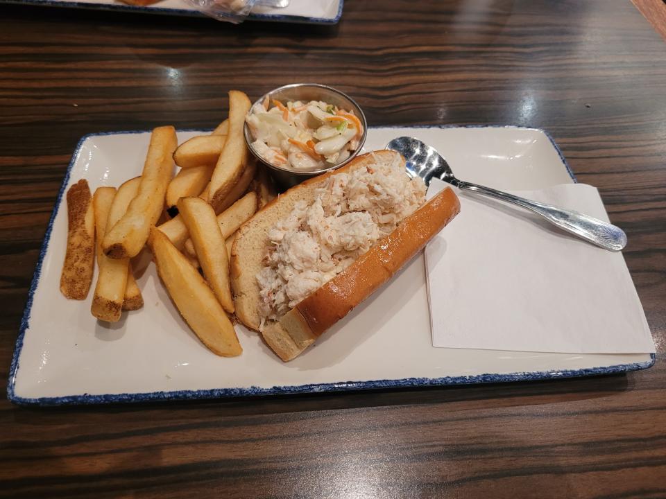 Legal Sea Foods crab roll on plate with fries and coleslaw