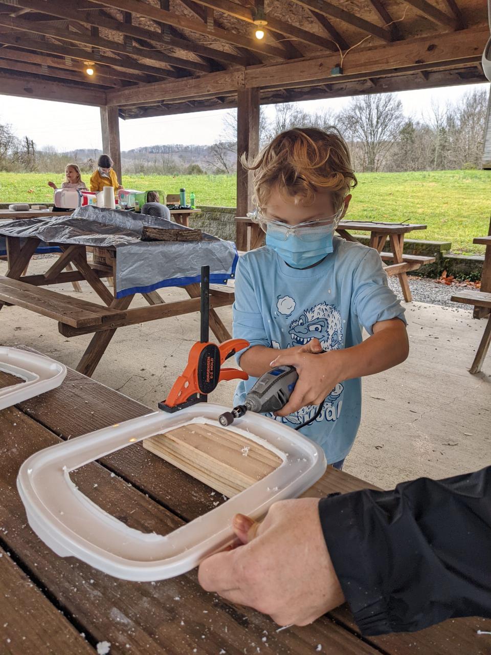 Hendrik Raiford-Davis uses a dremel to sand sharp edges on feral cat houses.