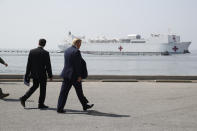 President Donald Trump and Defense Secretary Mark Esper, right, walk as the U.S. Navy hospital ship USNS Comfort takes off from the pier at Naval Station Norfolk in Norfolk, Va., Saturday, March 28, 2020. The ship is departing for New York to assist hospitals responding to the coronavirus outbreak. (AP Photo/Patrick Semansky)