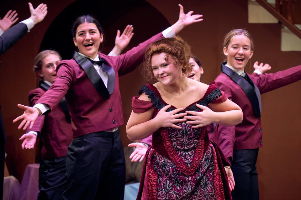 Molly Bishop, center, as Dolly Gallagher Levi, gets a warm welcome from the waiters at the Harmonia Gardens, including Ellie Brakatselos, left, and Madeleine Brandes, right, in "Hello, Dolly!" at Bronxville HIgh School. "Hello, Dolly" runs February 9-11 at Bronxville High School.