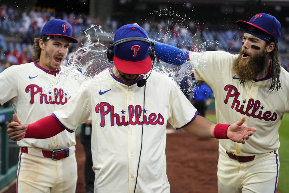 Philadelphia Phillies' Bryson Stott, left, and Brandon Marsh, right, dump water and candy on Whit Merrifield after winning a baseball game against the San Francisco Giants, Monday, May 6, 2024, in Philadelphia. (AP Photo/Matt Rourke)