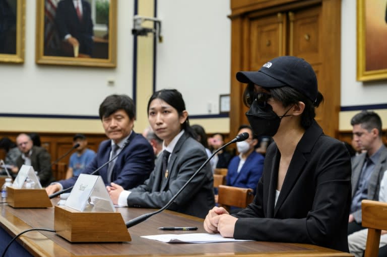 A disguised Columbia University student testifies before the Congressional-Executive Committee on China at a hearing that also included former Tiananmen Square leader Fengsuo Zhou (far left) (Drew ANGERER)