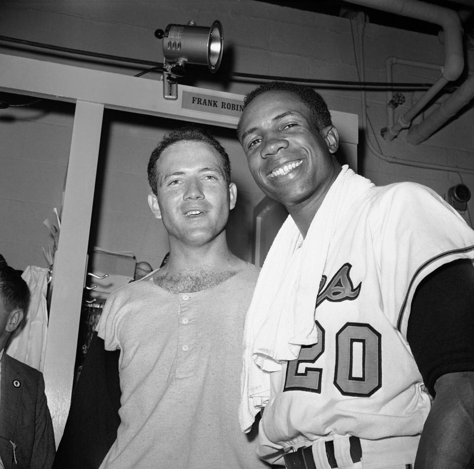 FILE - In this Oct. 9, 1966, file photo, pitcher Dave McNally, left, and right fielder Frank Robinson pose in the dressing room after the Orioles defeated the Los Angeles Dodgers to win the World Series, in Baltimore. Hall of Famer Frank Robinson, the first black manager in Major League Baseball and the only player to win the MVP award in both leagues, has died. He was 83. Robinson had been in hospice care at his home in Bel Air. MLB confirmed his death Thursday, Feb. 7, 2019. (AP Photo/File)