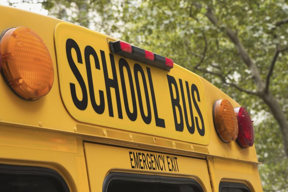 Back of school bus with a sign.