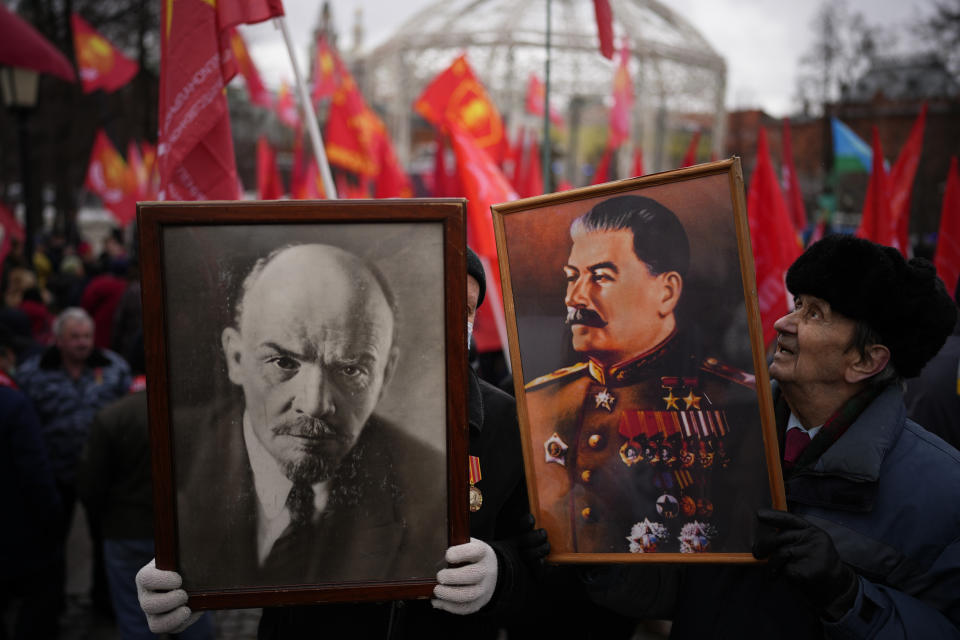 Partidarios del partido comunista sostienen retratos de Vladimir Lenin y Josef Stalin durante la celebración nacional del "Día del Defensor de la Patria" cerca del Kremlin, en la Plaza de la Revolución de Moscú, el 23 de febrero de 2022. (AP Foto/Alexander Zemlianichenko)