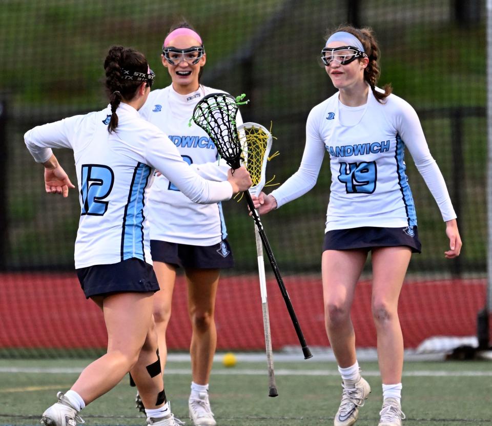 HYANNIS   5/04/23  Quinn Anderson (49) is joined with Sandwich teammates Riley Morrison (12) and Sophia Visceglio to celebrate their 8th goal in a 8-5  win over Nauset.