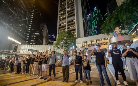 Demonstrators join hands to form a human chain during the Hong Kong Way event in the Central district of Hong Kong - Credit: Bloomberg