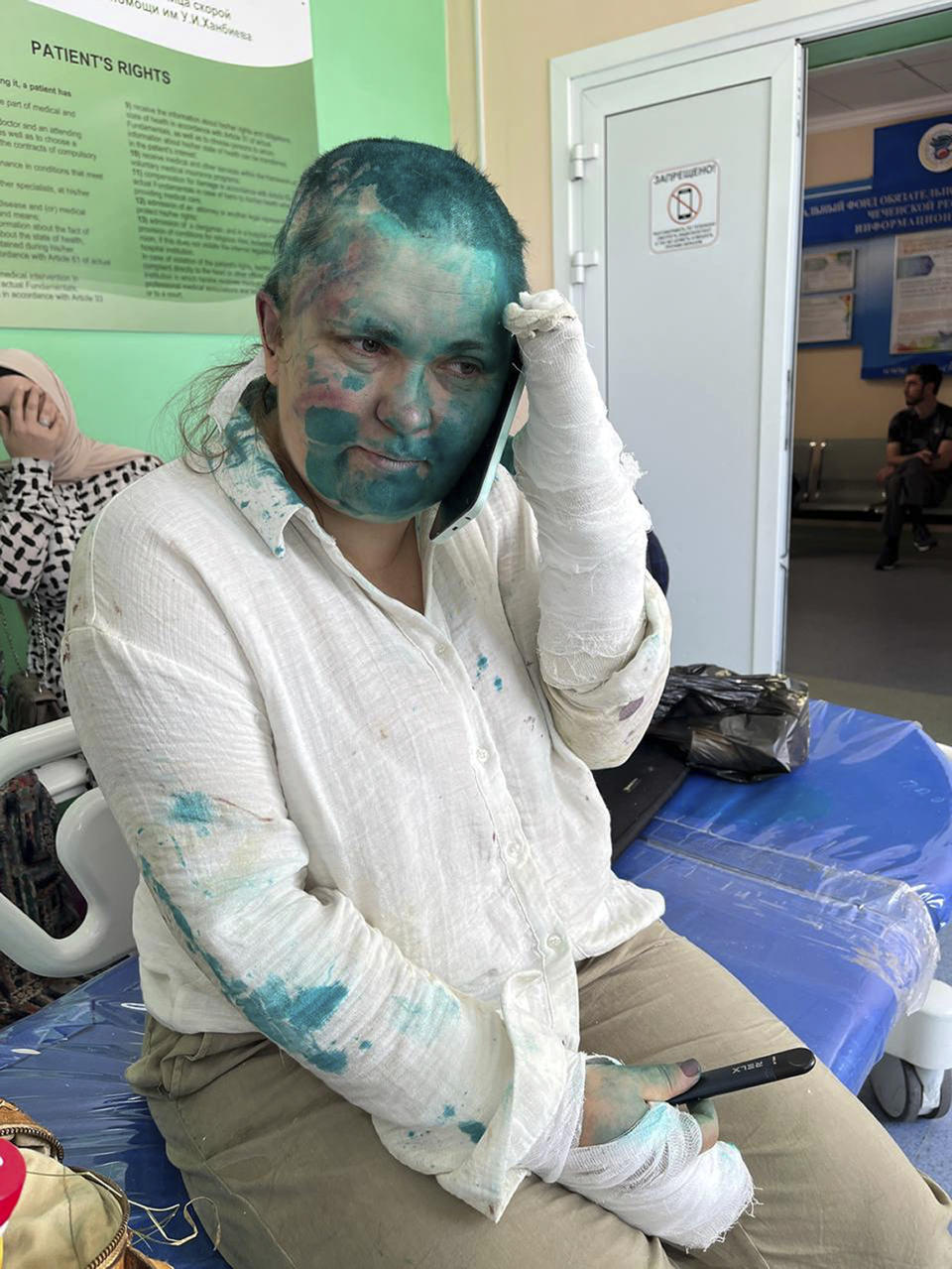 In this handout photo released by Novaya Gazeta Europe via web site Novayagazeta.eu on Tuesday, July 4, 2023, Novaya Gazeta journalist Elena Milashina sitts after giving her a medical treatment in Grozny, Russia. Unidentified masked assailants in the Russian province of Chechnya have attacked and beaten a journalist and a lawyer. The violent incident underlines human rights abuses in the region. Novaya Gazeta journalist Elena Milashina and lawyer Alexander Nemov had just arrived in Chechnya to attend the trial of Zarema Musayeva, the mother of two local activists who have challenged Chechen authorities. (Novaya Gazeta Europe Novayagazeta.eu via AP)