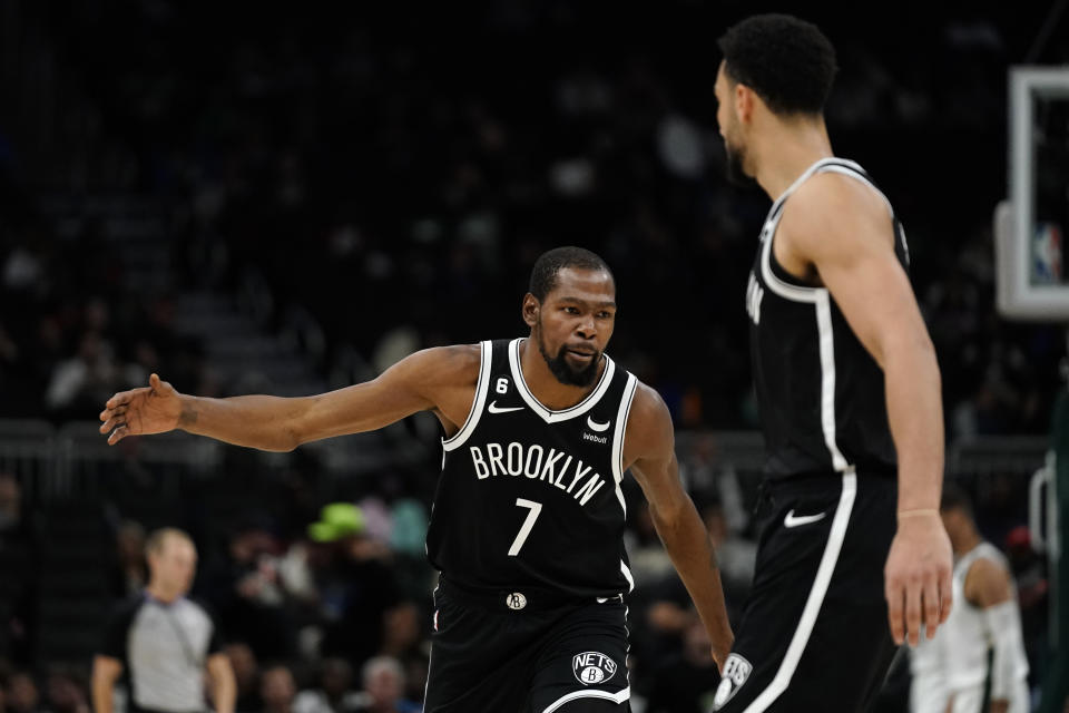 Brooklyn Nets' Kevin Durant (7) celebrates with Ben Simmons during the second half of the team's NBA preseason basketball game against the Milwaukee Bucks on Wednesday, Oct. 12, 2022, in Milwaukee. (AP Photo/Aaron Gash)