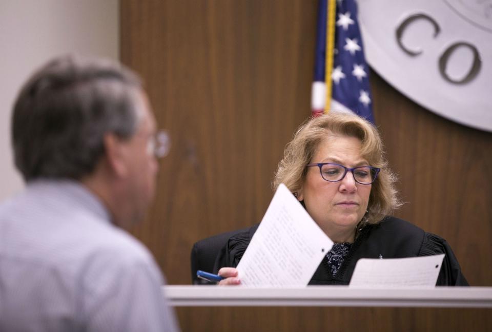 Judge Anna Huberman looks at a paperwork from a tenant as Kevin Holliday, an attorney for the landlord, looks on during eviction court at the Maricopa County court building, Agua Fria Justice Court, in Tolleson on Aug. 15, 2018.