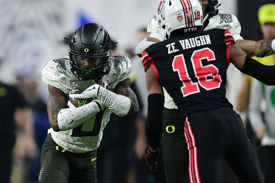 Oregon running back Seven McGee tries to get past Utah safety Zemaiah Vaughn (16) during the first half of Friday's Pac-12 championship game.