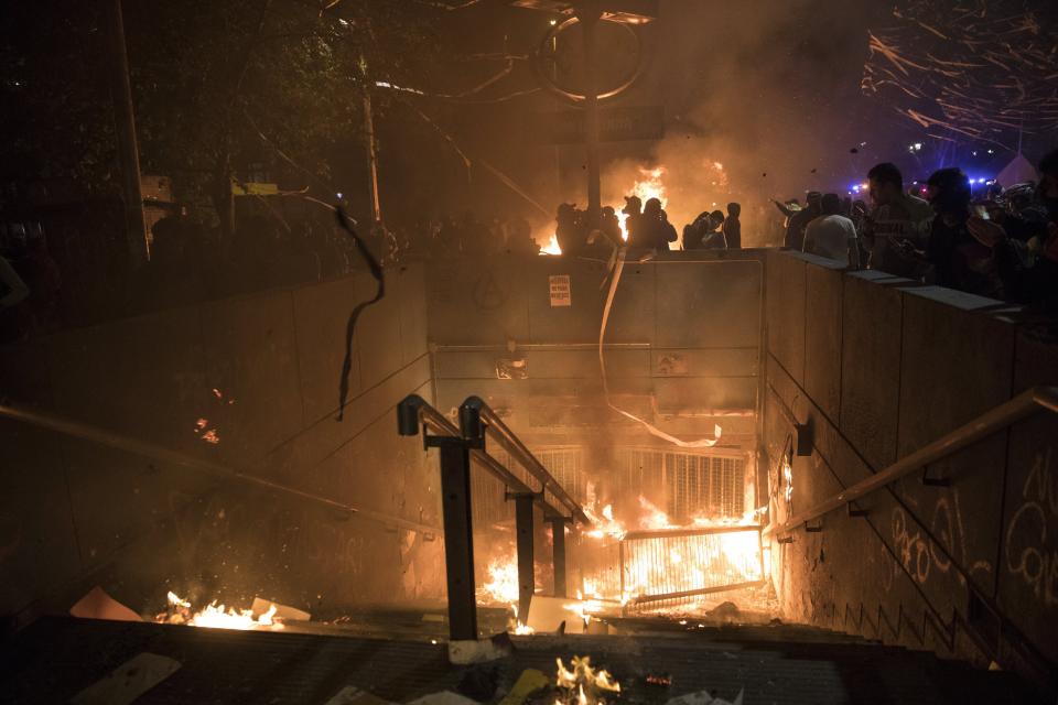 Anti-government protesters burn a subway station in Santiago, Chile, Monday, Oct. 28, 2019. Fresh protests and attacks on businesses erupted in Chile Monday despite President Sebastián Piñera's replacement of eight important Cabinet ministers with more centrist figures, and his attempts to assure the country that he had heard calls for greater equality and improved social services. (AP Photo/Rodrigo Abd)