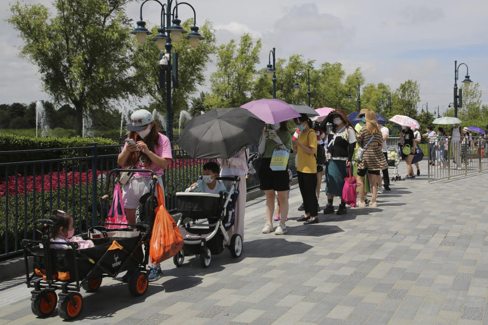 Visitors line up outside the Disney Resort theme park, Thursday, June 30, 2022, in Shanghai. Shanghai is moving to allow in-person dining and reopening its Disney Resort theme park as domestically transmitted cases of COVID-19 in China's largest city remain at zero following a more than two-month lockdown. (AP Photo/Chen Si)