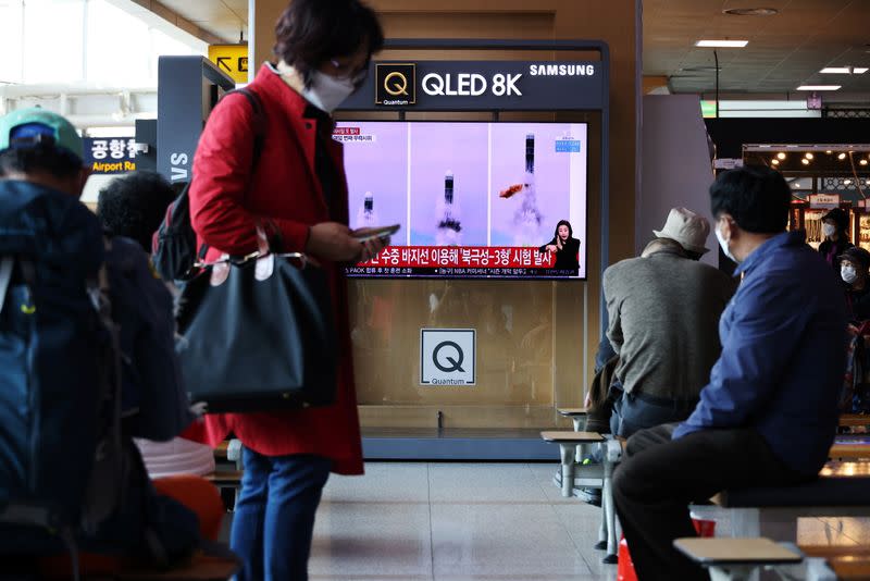 People watch a TV broadcasting file footage of a news report on North Korea firing a ballistic missile off its east coast, in Seoul