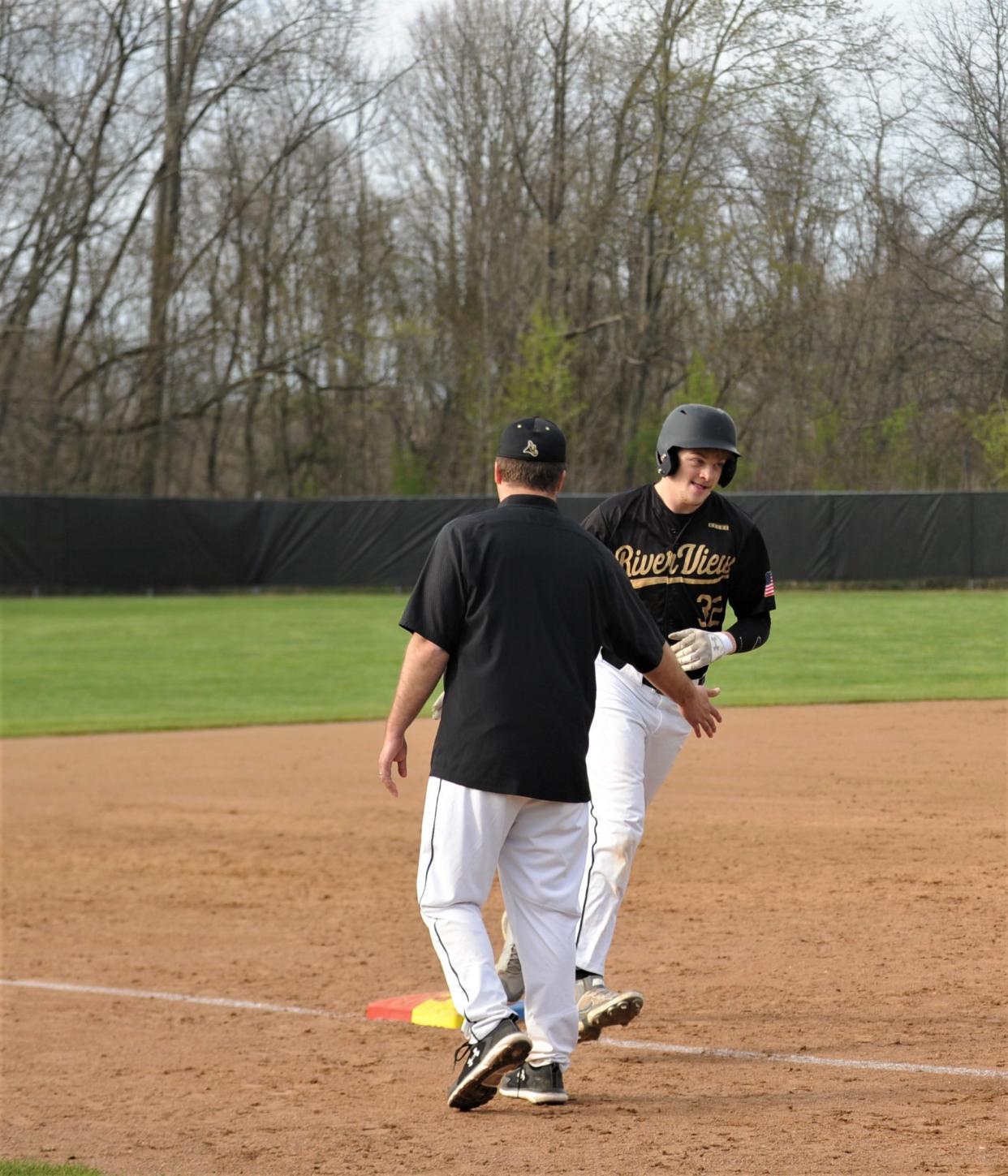 River View coach Todd Liberatore congratulates Cruz Mobley after his solo home run in the fifth inning of a 7-3 loss to John Glenn.