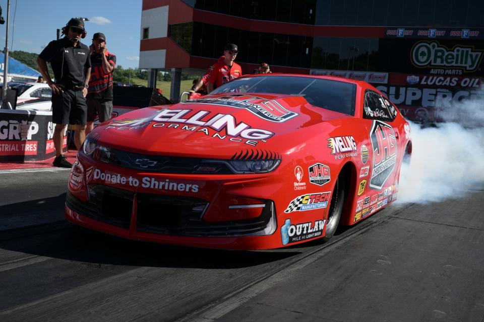 a red race car with smoke coming out of the tires