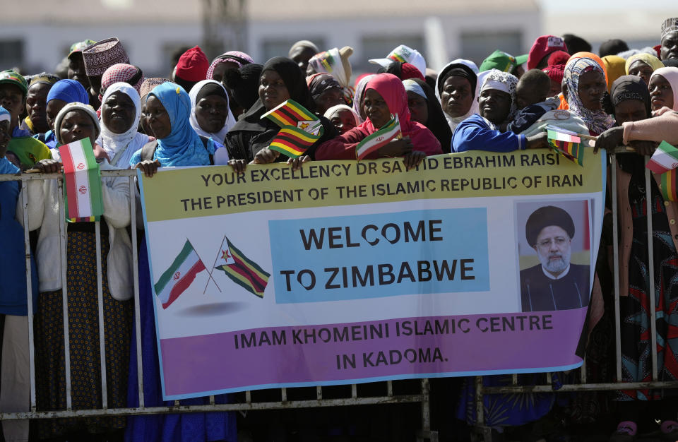 Supporters of Iran's President Ebrahim Raisi welcome him upon his arrival at Robert Mugabe airport in Harare, Zimbabwe, Thursday, July 13, 2023. Iran's president is on a rare visit to Africa as the country, which is under heavy U.S. economic sanctions, seeks to deepen partnerships around the world. (AP Photo/Tsvangirayi Mukwazhi)