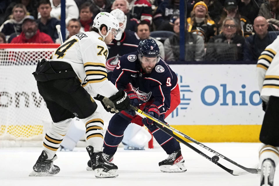 Boston Bruins left wing Jake DeBrusk (74) and Columbus Blue Jackets defenseman Ivan Provorov (9) fight for control of the puck in the second period of an NHL hockey game Tuesday, Jan. 2, 2024, in Columbus, Ohio. (AP Photo/Sue Ogrocki)