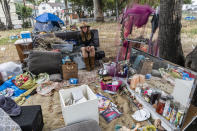 Dawn Woodward, 39, who is homeless and originally from Arizona, sits outdoors in a homeless camp on the side of the CA-101 highway in Echo Park neighborhood in Los Angeles Tuesday, May 11, 2021. California Gov. Gavin Newsom on Tuesday proposed $12 billion in new funding to get more people experiencing homelessness in the state into housing and to “functionally end family homelessness” within five years. (AP Photo/Damian Dovarganes)