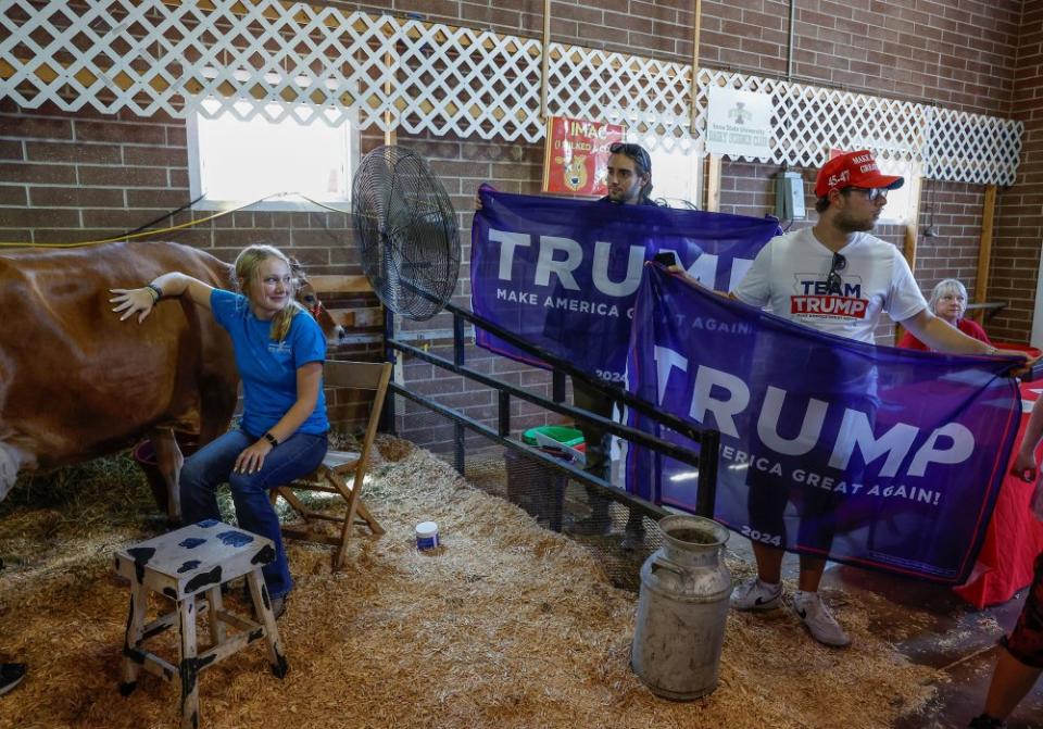 Trump campaign workers hold Trump flags for a photo opportunity with Kari Lake, former Republican candidate for Governor of Arizona, at the cattle barn on Aug. 11.<span class="copyright">Evelyn Hockstein—Reuters</span>