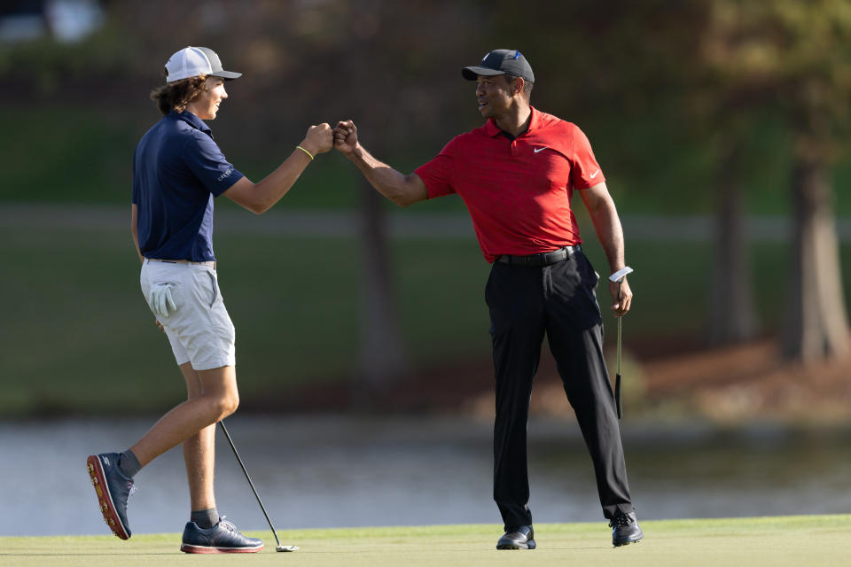 Tiger Woods fist bumping Cameron Kuchar after he drained a long putt on the 17th green during the final round of the PNC Championship golf tournament at Grande Lakes Orlando Course.  Mandatory Credit: Jeremy Reper-USA TODAY Sports
