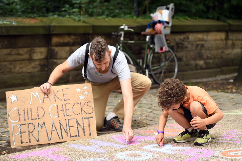 BROOKLYN, NEW YORK - JULY 12: Justin Ruben and Rime Leonard draw with chalke to celebrate new monthly Child Tax Credit payments and urge congress to make them permanent outside Senator Schumer's home on July 12, 2021 in Brooklyn, New York. (Photo by Bryan Bedder/Getty Images for ParentsTogether)