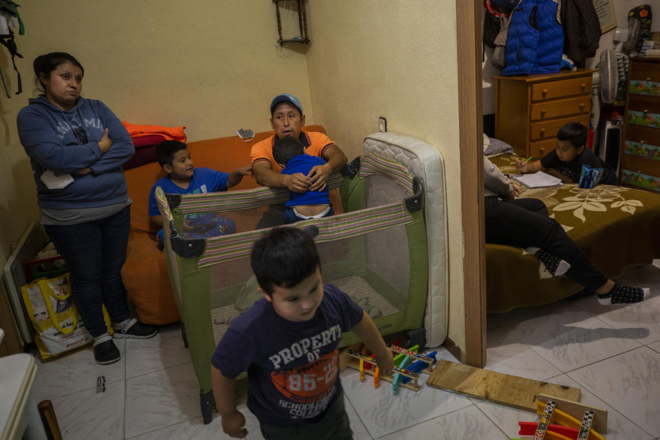 Erika Oliva, left, and her husband Benjamin Lopez's family gather inside their apartment in the southern neighbourhood of Vallecas in Madrid, Spain, Thursday Oct. 15, 2020. The COVID-19 contagion has spread faster in densely populated working-class neighborhoods like Vallecas, where Oliva's family of seven share a 35 square-meter street-level apartment. (AP Photo/Bernat Armangue)