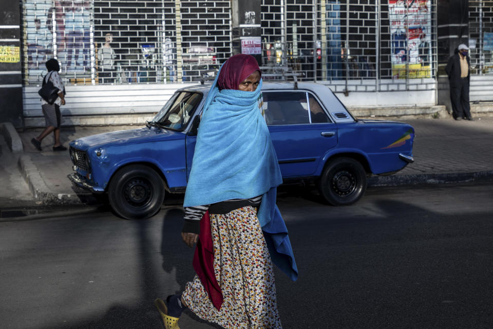A woman walks down a street in the capital Addis Ababa, Ethiopia Friday, Nov. 13, 2020. Tensions over the deadly conflict in Ethiopia are spreading well beyond its cut-off northern Tigray region, as the federal government said some 150 suspected "operatives" accused of seeking to "strike fear and terror" throughout the country had been detained. (AP Photo/Mulugeta Ayene)