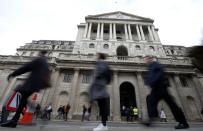 People walk in front of the Bank of England, following an outbreak of the coronavirus, in London