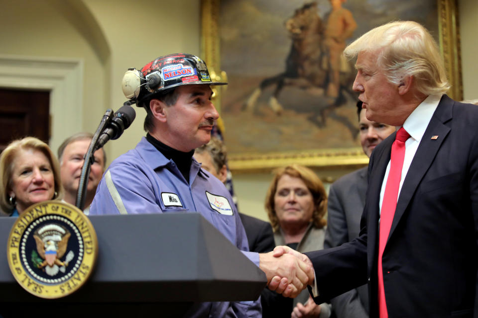 Coal miner Michael Nelson shakes hands with President Donald Trump as Trump prepares to sign Resolution 38, which nullifies the coal industry's "stream protection rule." (Photo: Carlos Barria / Reuters)