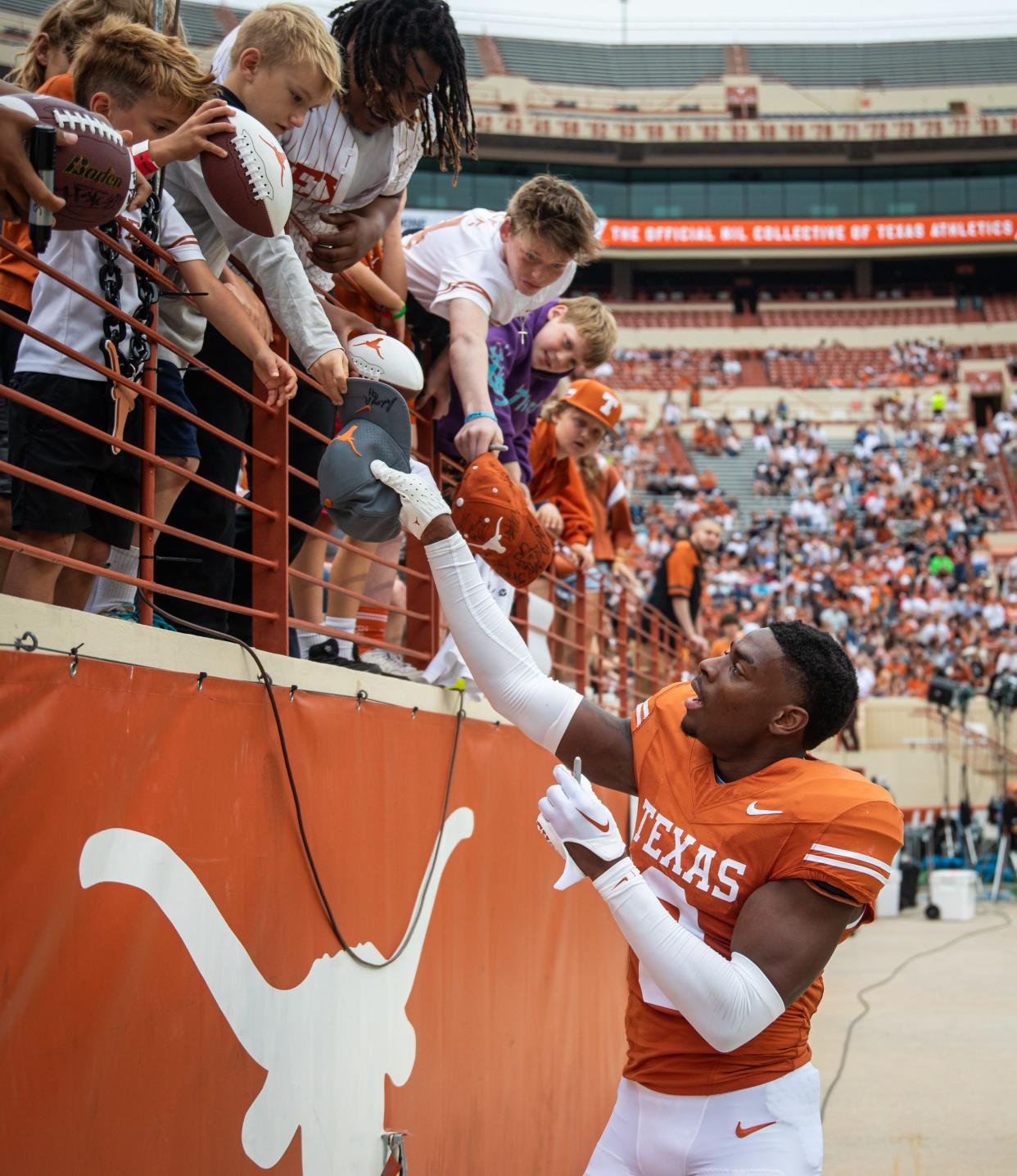 Texas defensive back Terrance Brooks signs autographs for fans during Saturday's Orange-White spring game at Royal-Memorial Stadium. Three days later, he announced that he's entering the transfer portal. Brooks started 13 games last season.