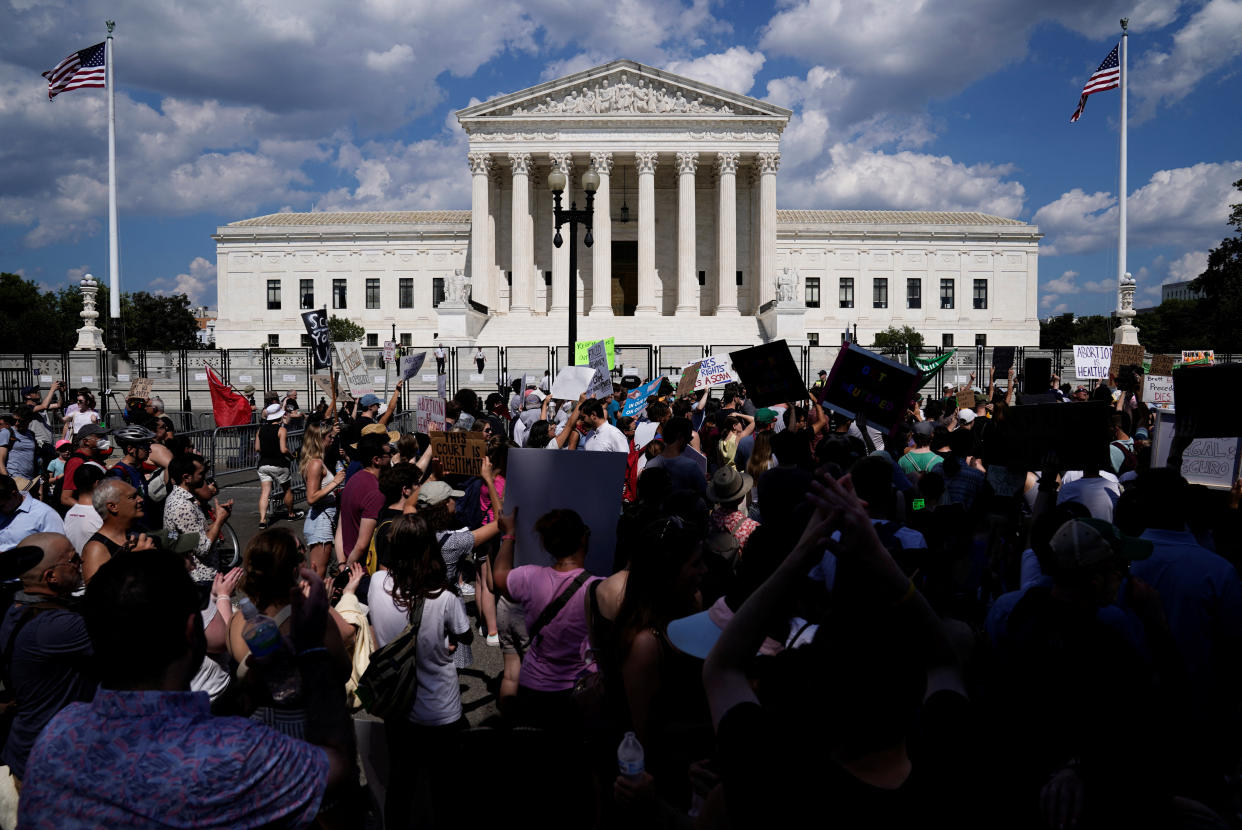 Abortion rights supporters protest, carrying signs saying, for example, Abortion Is Healthcare, and 