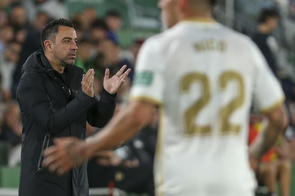 Barcelona's head coach Xavi Hernandez, left, applauds during a Spanish La Liga soccer match between Elche and Barcelona, at the Martinez Valero Stadium in Elche, Spain, Saturday, April 1, 2023. (AP Photo/Alberto Saiz)