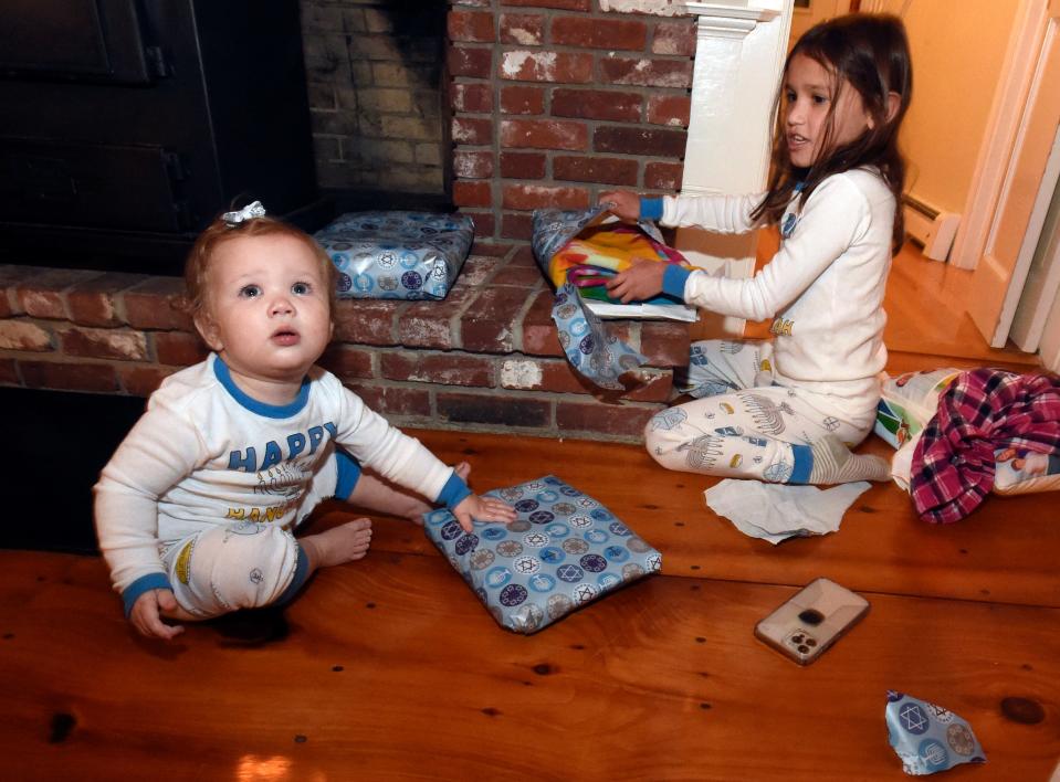 Maggie and Rebecca De La Vega open presents as part of Hanukkah.