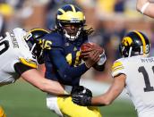 ANN ARBOR, MI - NOVEMBER 17: Denard Robinson #16 of the Michigan Wolverines tries to split the tackles of Louis Trinca-Pasat #90 and Micah Hyde #18 of the Iowa Hawkeyes at Michigan Stadium on November 17, 2012 in Ann Arbor, Michigan. (Photo by Gregory Shamus/Getty Images)
